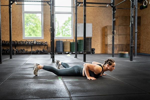 Woman doing burpees in gym for high-intensity fat loss
