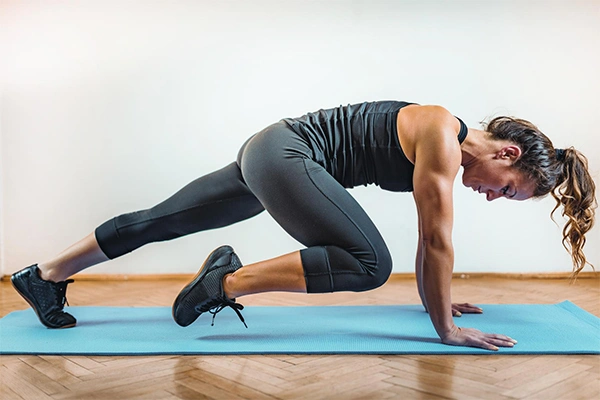 Woman performing mountain climbers on a yoga mat for belly fat loss