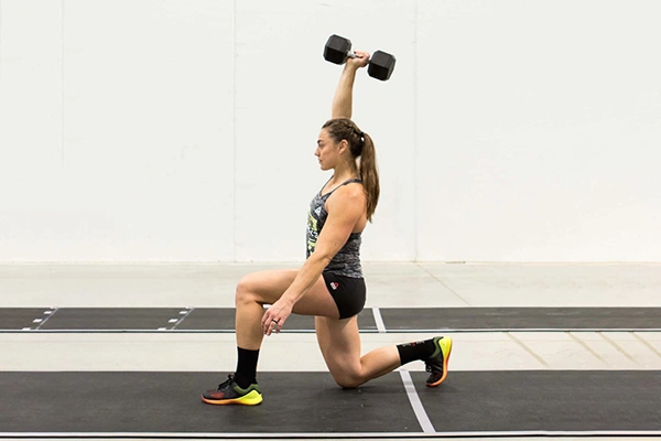 Woman doing lunges with a dumbbell for core and leg strength