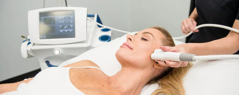 Aesthetic professional performing non-invasive body sculpting on a client using advanced contouring equipment