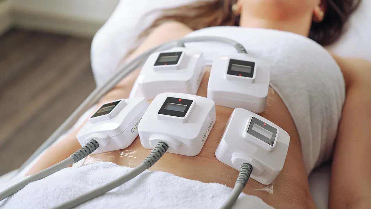 Woman receiving Venus Legacy RF body sculpting treatment on her abdomen in a clinical setting