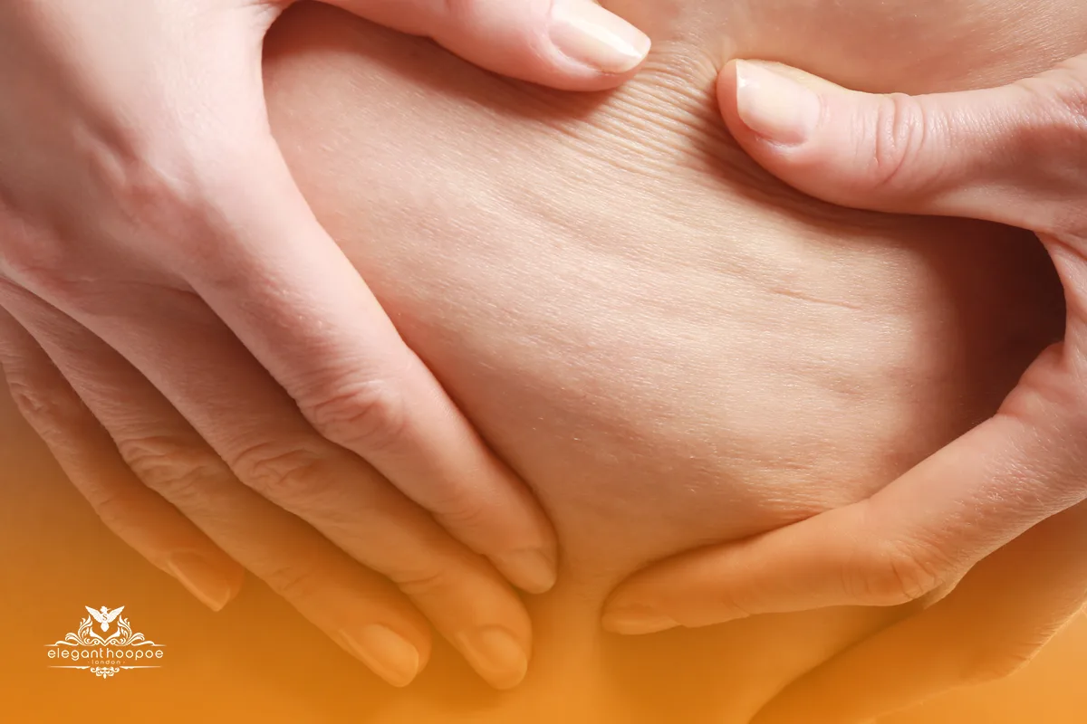 Close-up of hands performing an anti-cellulite massage on thigh skin