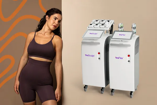 Woman in athletic wear standing next to truSculpt and truFlex machines