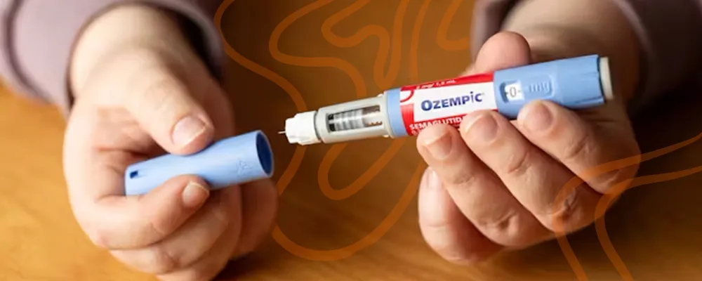 Ozempic pen being held, a medication used for fat reduction and weight management. 