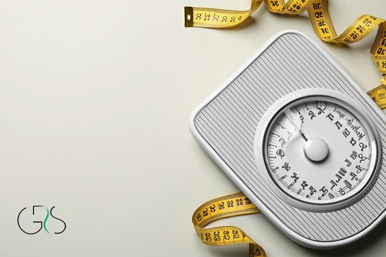 Gray bathroom scale with yellow measuring tape beside it 