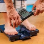 Person using a digital body composition scale with handles for advanced BMI and body metrics measurement
