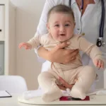 Pediatrician weighing a baby during a growth checkup