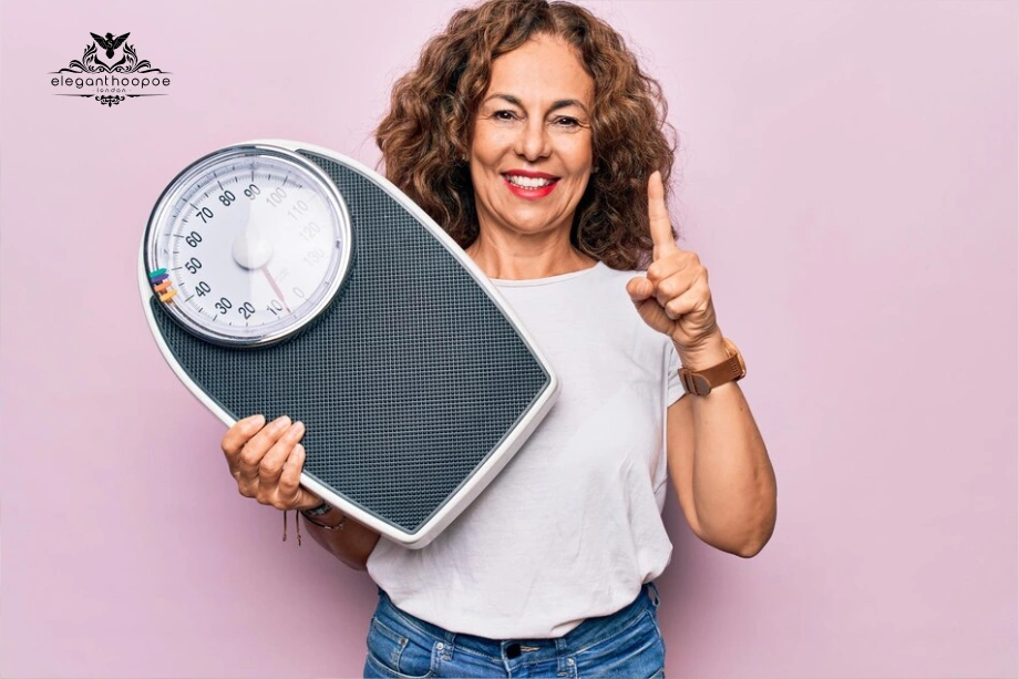 Smiling woman holding a bathroom scale and pointing up after calculating BMI