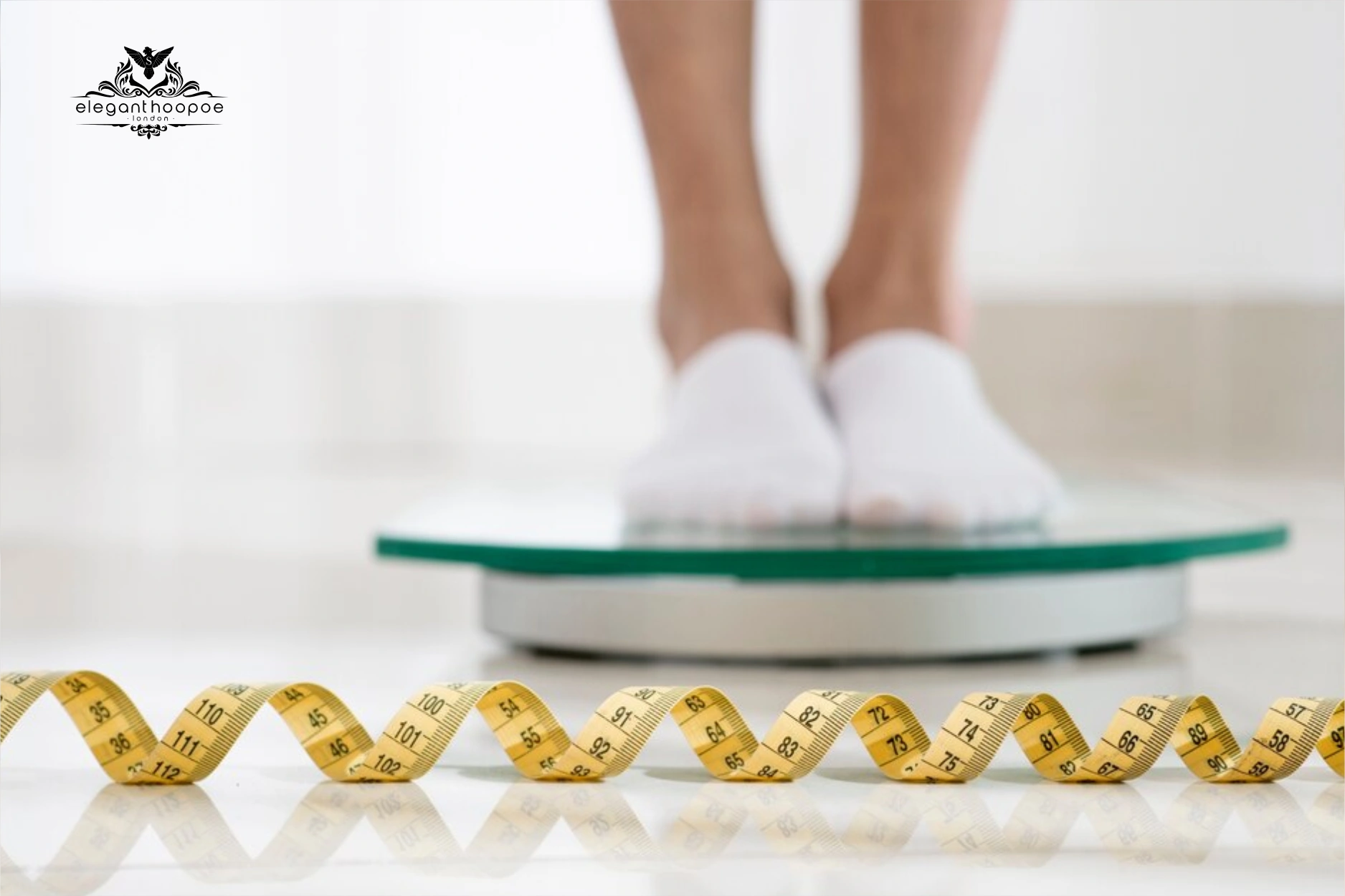 Person standing on a digital scale with yellow measuring tape in the foreground.