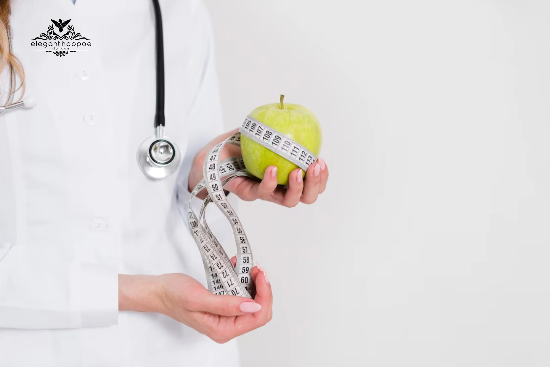 Female doctor holding green apple and measuring tape to promote healthy BMI.