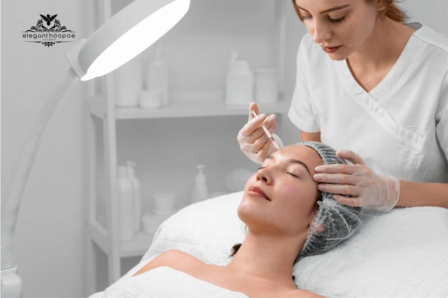Nurse injecting Botox into woman’s forehead under examination lamp