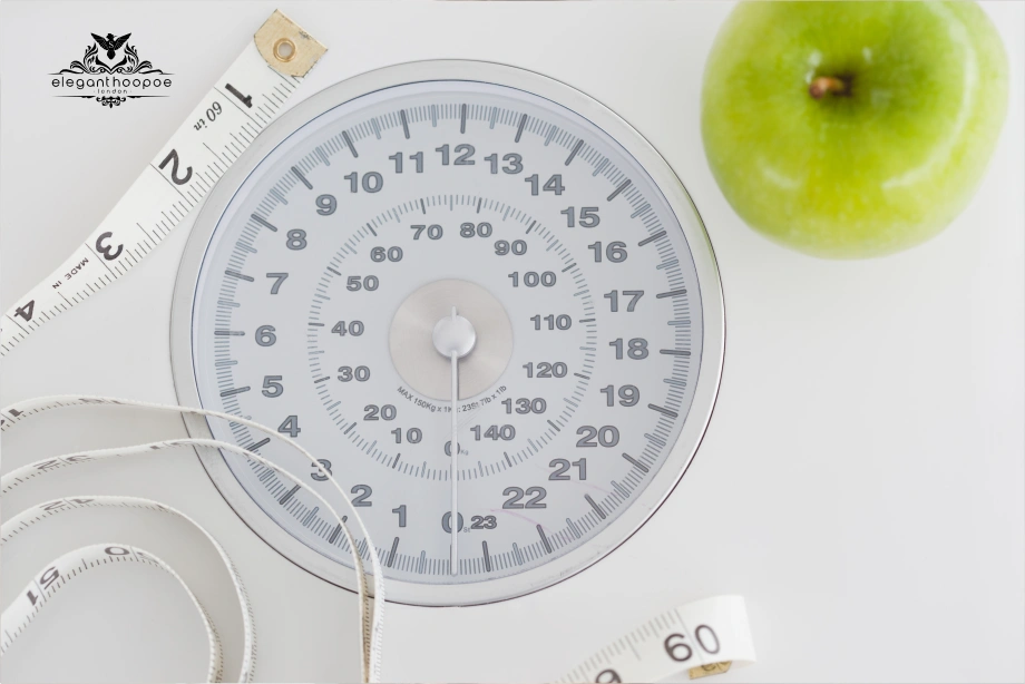 Close-up of a mechanical bathroom scale, measuring tape, and a green apple representing healthy BMI management.