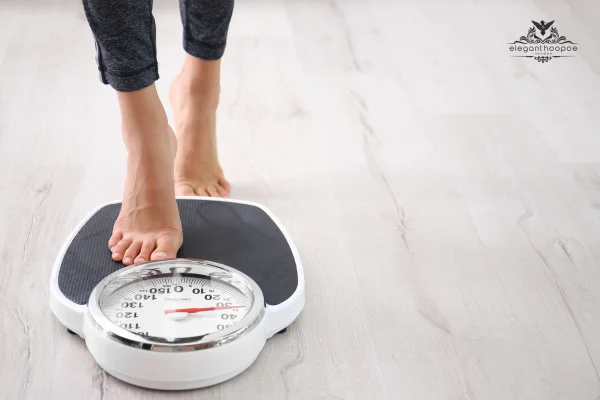 Pregnant woman checking her weight on a scale