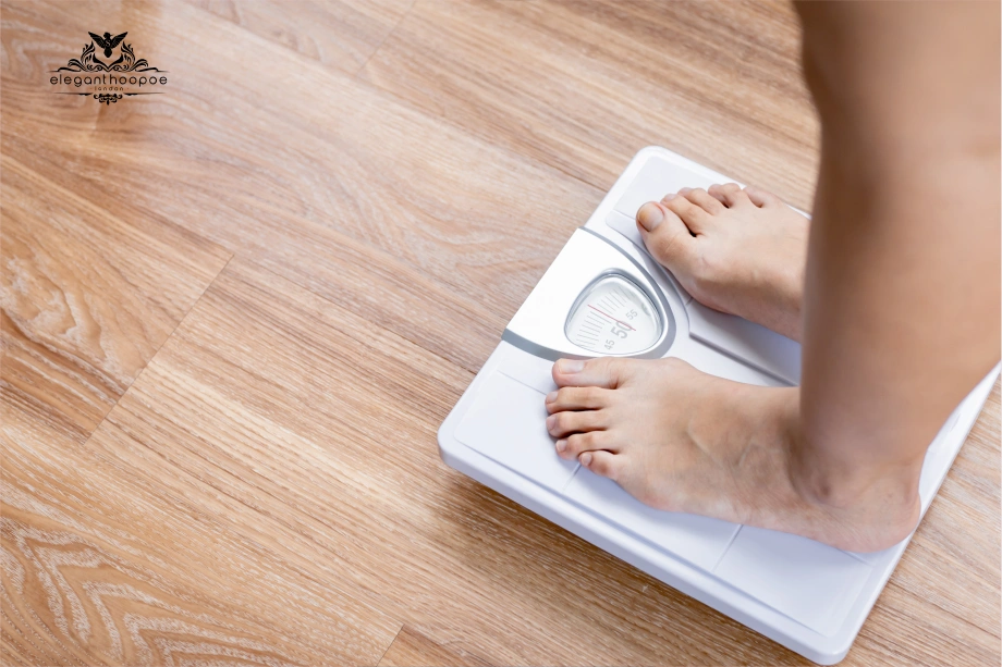 Person standing barefoot on a scale to check weight for BMI.