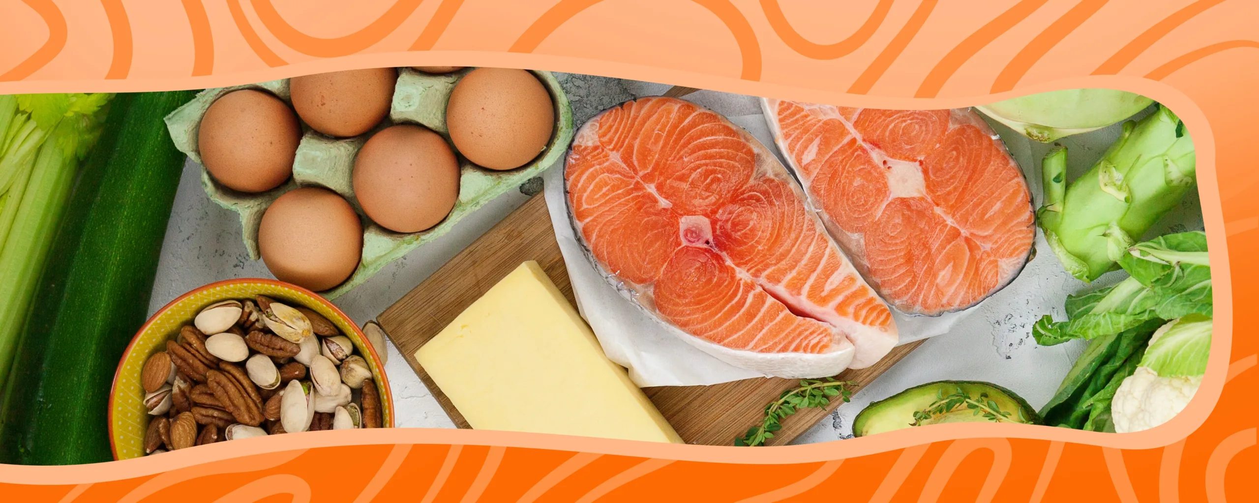 Selection of keto diet safe foods including salmon, eggs, cheese, nuts, avocado, and green vegetables on a table.