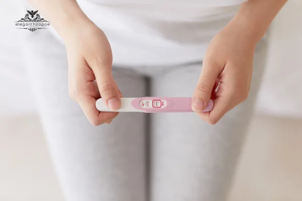 Woman holding a positive pregnancy test