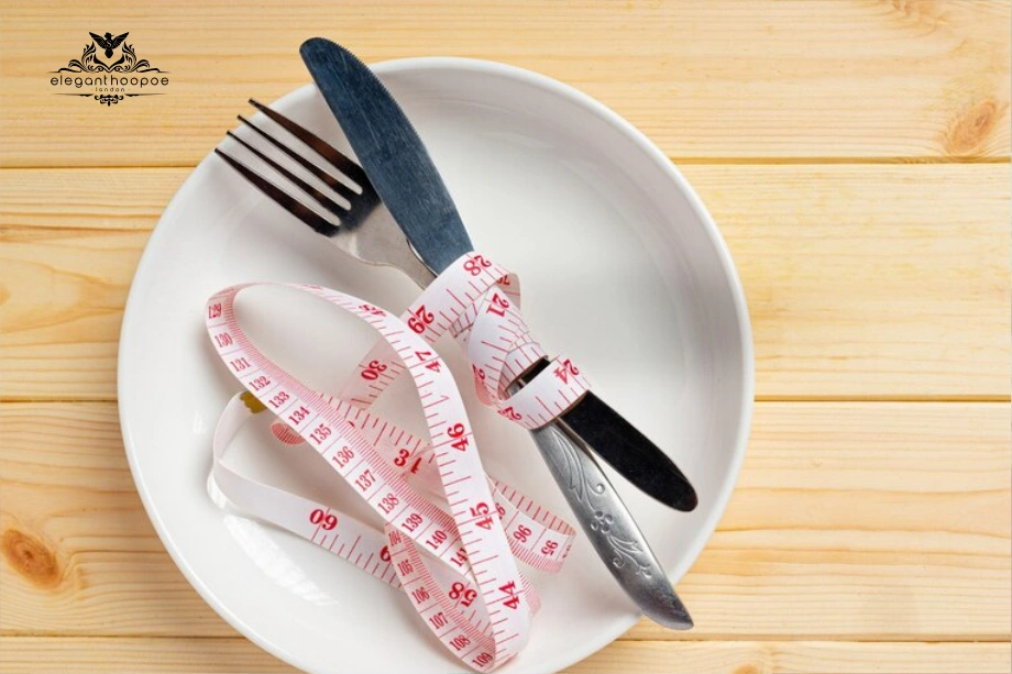 Empty plate with fork, knife, and measuring tape symbolizing mindful eating.