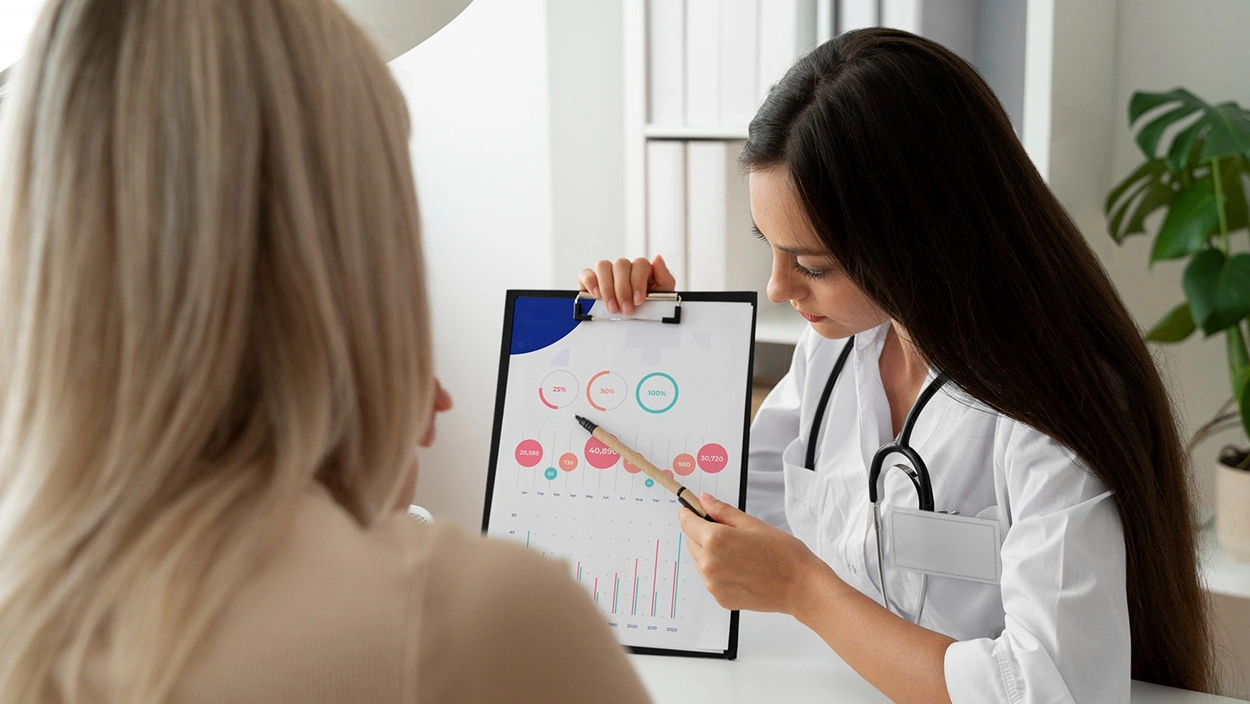 Doctor explains BMI vs. Waist-to-Hip Ratio chart to female patient during health check
