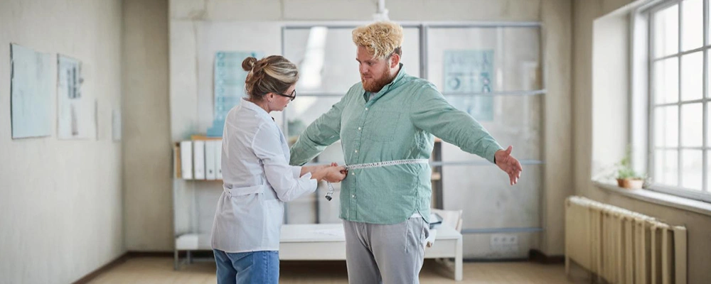 Doctor measuring an overweight patient’s waist to illustrate visual BMI and fat distribution