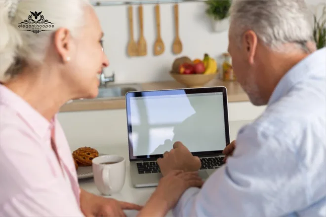 Seniors reviewing BMI and Age chart on laptop in kitchen
