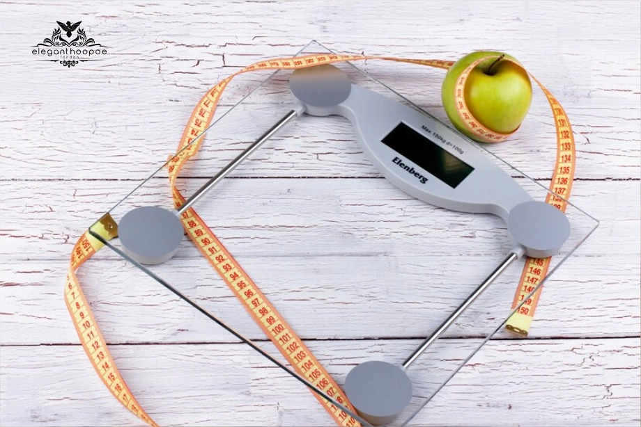 Glass digital scale wrapped in tape measure with green apple, reinforcing the role of BMI calculator with body measurements in maintaining health