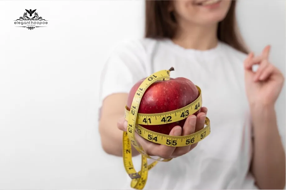 Person holding a red apple wrapped in a yellow measuring tape, symbolizing the measurement of BMI and the impact of height on health metrics.