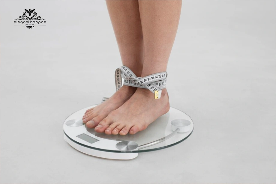 Feet on bathroom scale wrapped with tape measure symbolising body fat percentage vs. body weight
