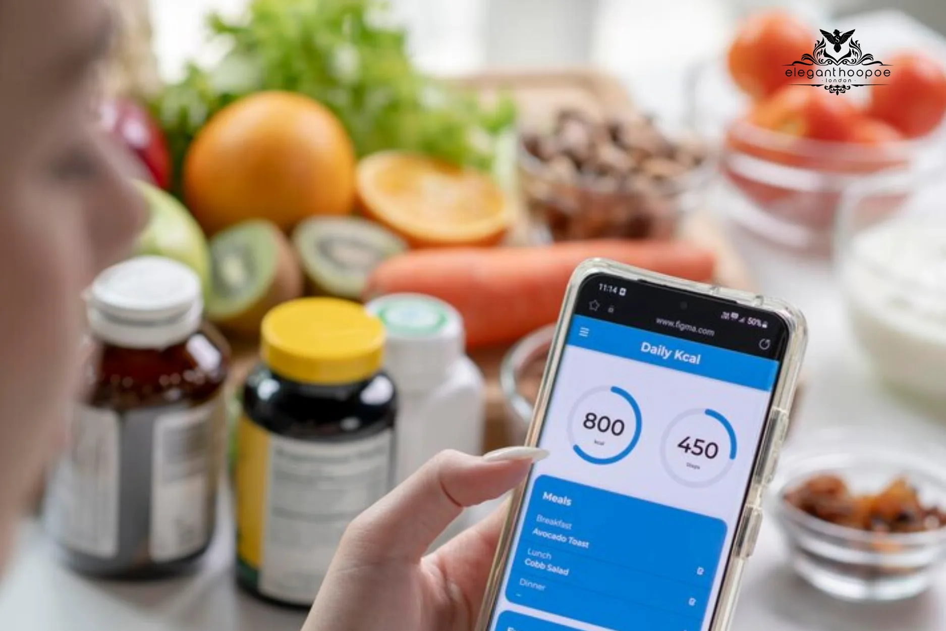 Person holding a smartphone with a BMI calculator app open, sitting at a table with healthy snacks, supplements, and notepad.