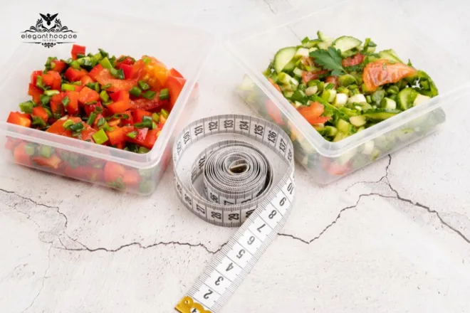 Two containers with colorful chopped vegetables and a rolled measuring tape on a cracked white surface, symbolizing portion control and BMI awareness.