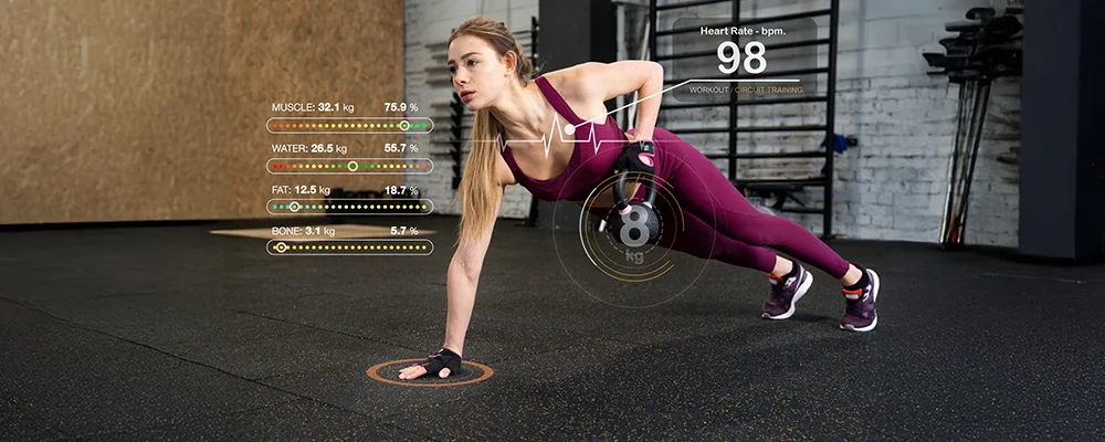 Woman in plank position on gym floor with overlay displaying muscle mass, water percentage, fat percentage, bone mass, and heart rate